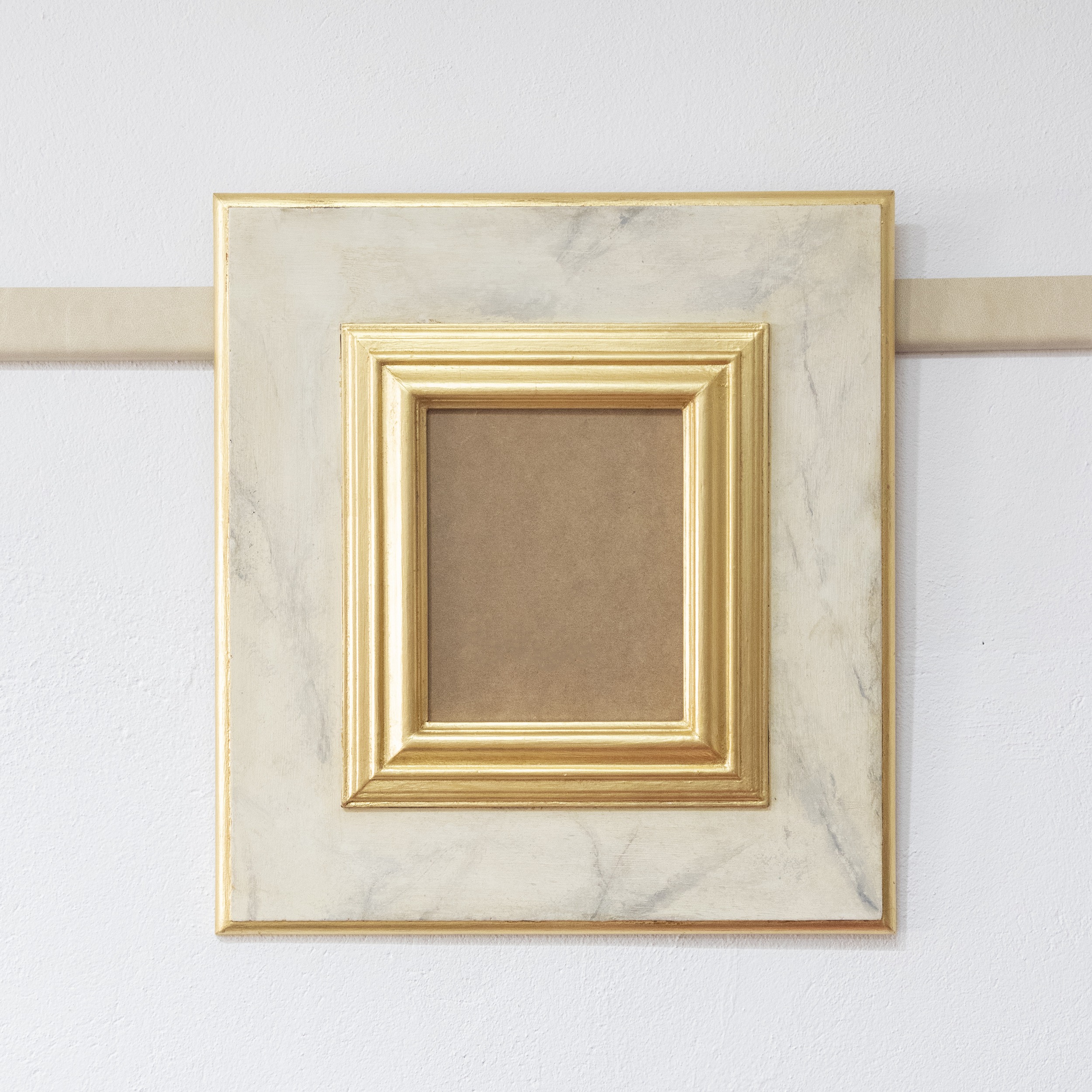 Marco dorado e imitación a mármol blanco